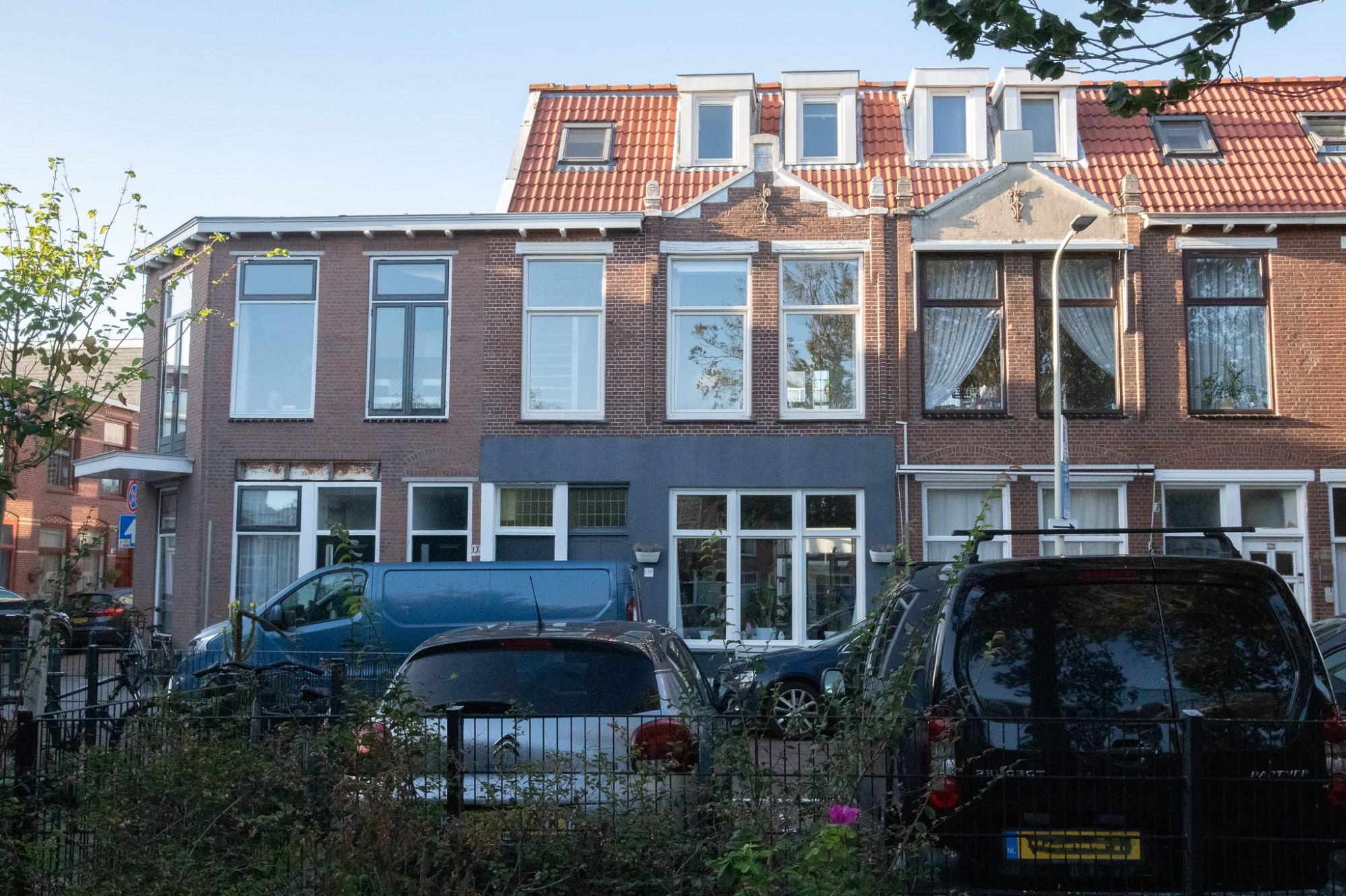 Gevel van het dubbele bovenhuis met dakkapellen en rode pannen